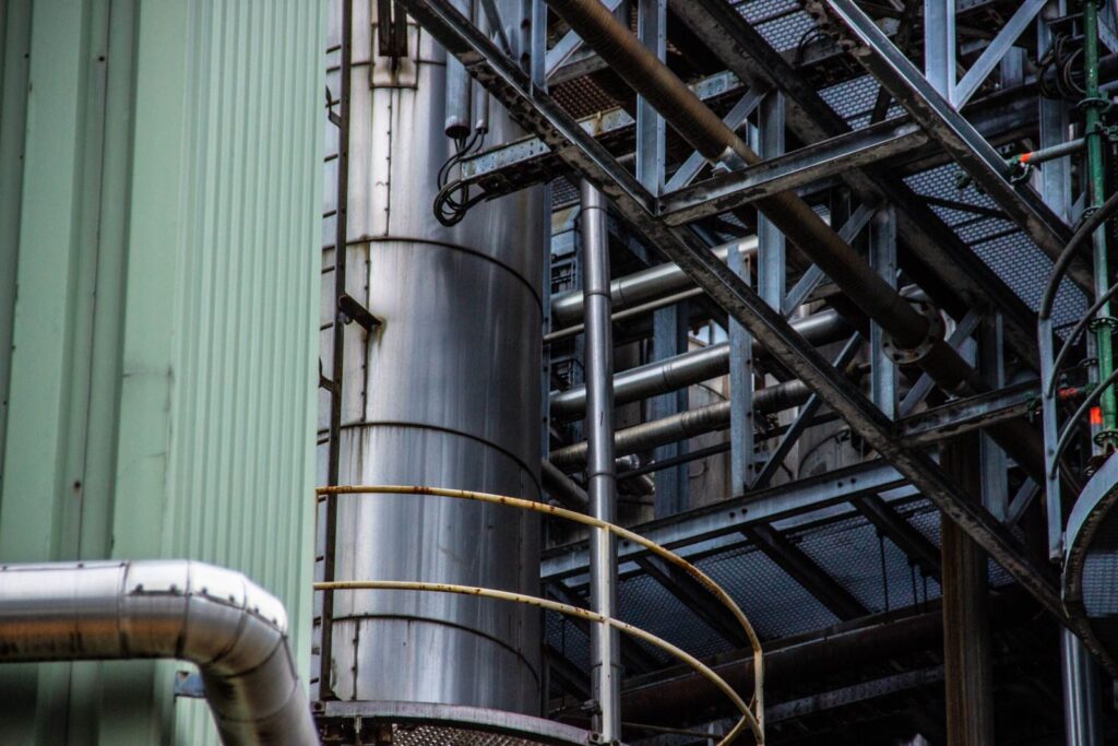 Close-up of an industrial metal structure with pipes and steel framework seen outdoors.